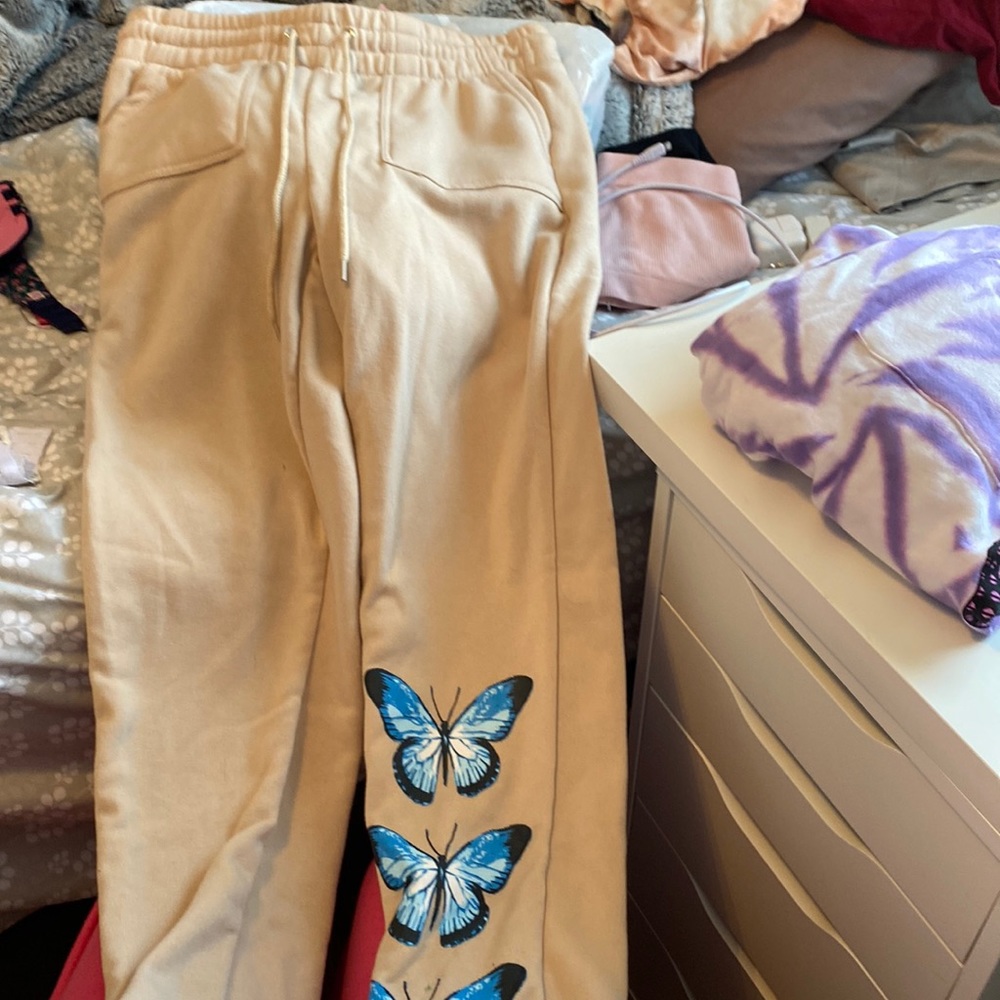 Great quality, and body fitting brown joggers with blue butterflies.